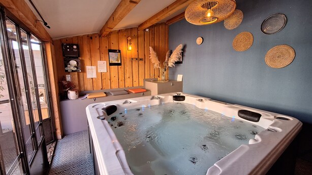 Ein Wellnessraum mit Whirlpool, Holzwänden und einem Fenster.