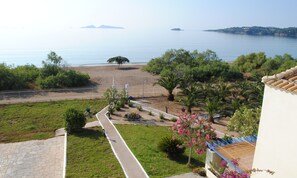 A coastal view with a beach, palm trees, and a clear sky. - Grand Bleu Anastazia (Ermionida)