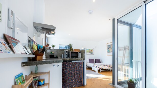 A modern kitchen with a microwave, coffee maker, and a small dining area with a table and chairs.