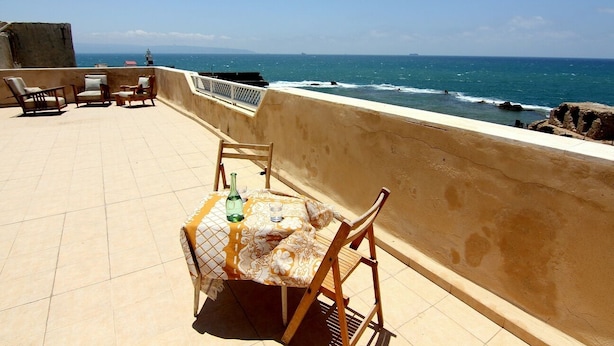 A terrace with a table and chairs overlooking the sea. - Nzar Khoury For Hosting (Acre)