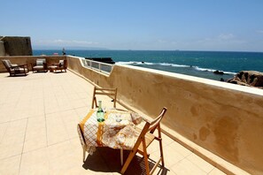 A terrace with a table and chairs overlooking the sea. - Nzar Khoury For Hosting (Acre)