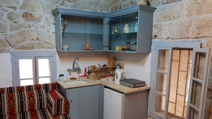 A compact kitchen with a sink, a small refrigerator, and a window with a view. - Nzar Khoury For Hosting (Acre)