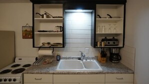 A kitchen with a double sink, white cabinets, and a stove. - Pet friendly fully furnished and private 1 Bedroom Flat (Fond du Lac)