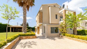 A modern two-story house with a flat roof, large windows, and a satellite dish. - Villa Nefeli (Nea Propontida)