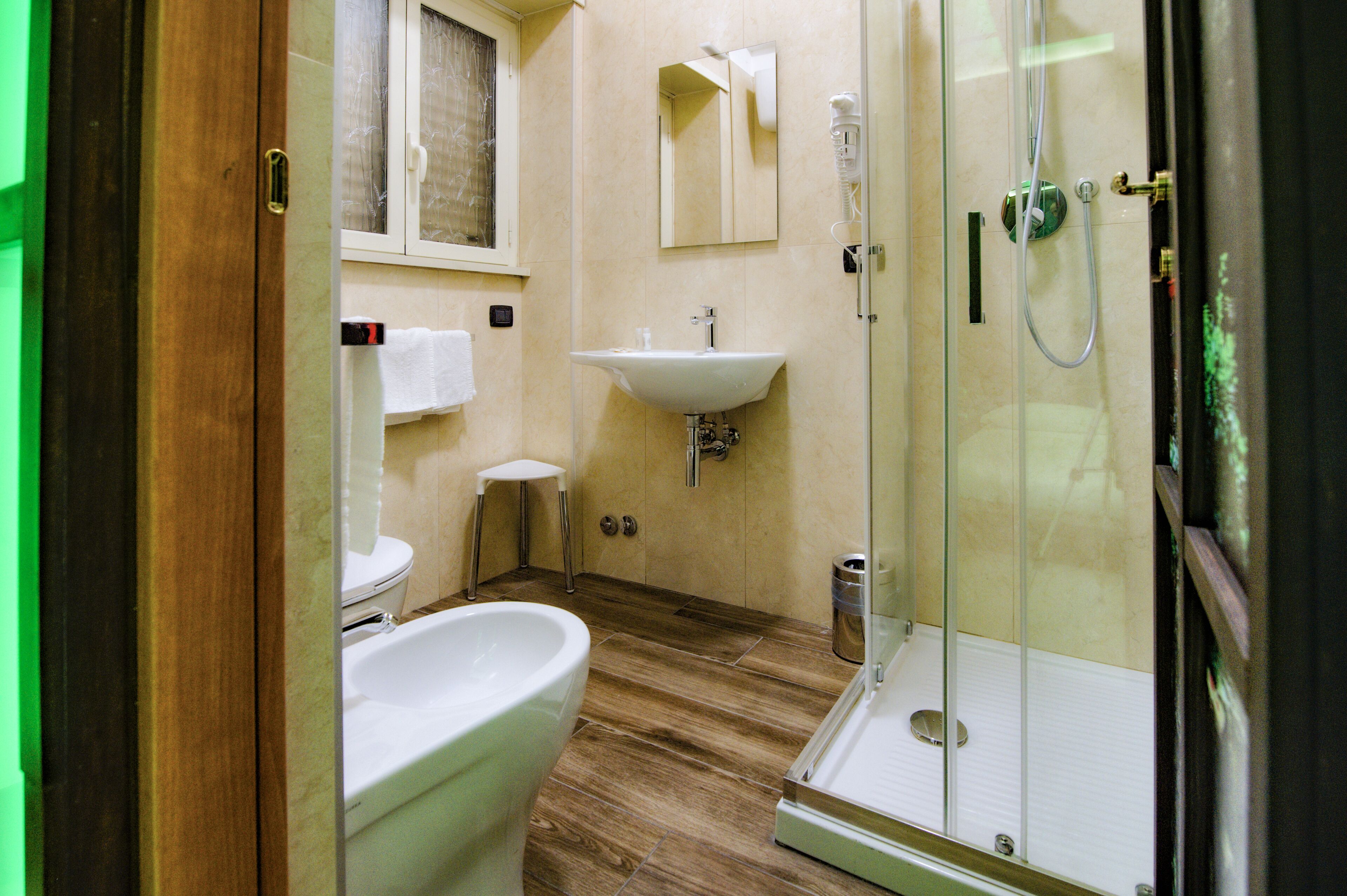 A bathroom with a toilet, sink, and shower.