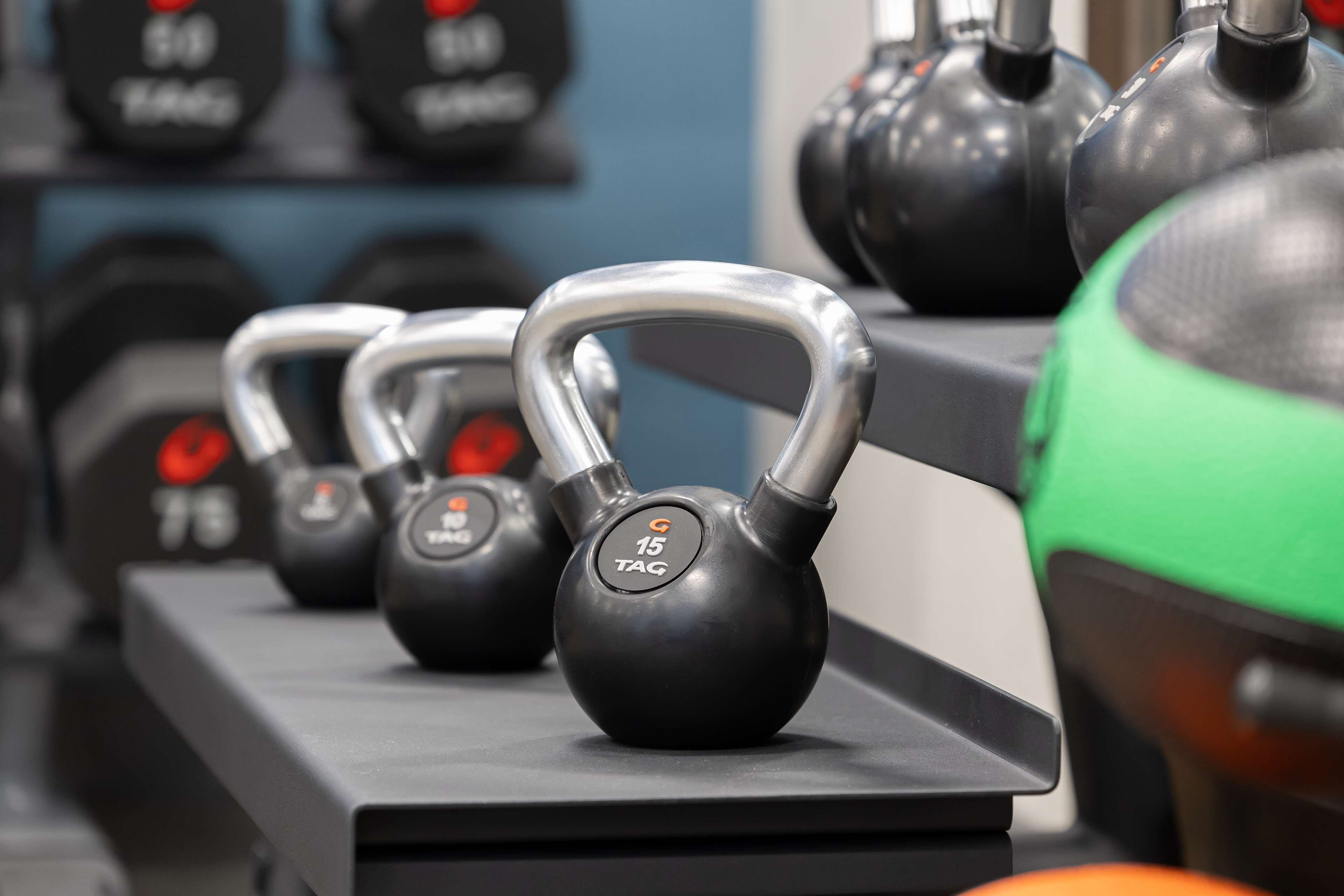Kettlebells of various weights arranged on a rack.