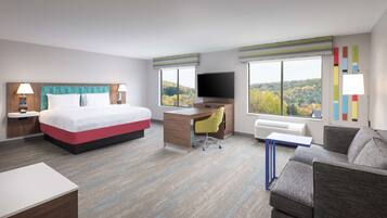 Una habitación de hotel con cama, escritorio y sofá.