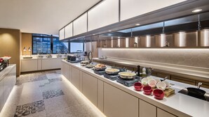 Una cocina moderna con una encimera larga, electrodomésticos integrados y vistas a la ciudad.