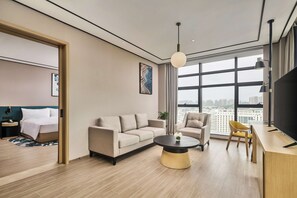 Suíte luxo, 1 cama King, sacada | Área de estar | TV de tela plana 55 polegadas com canais a cabo, TV