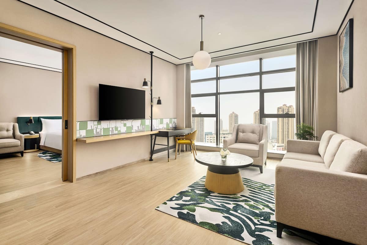 Suite Deluxe, 1 cama de matrimonio grande | Zona de estar | Televisión de pantalla plana de 55 pulgadas con canales por cable