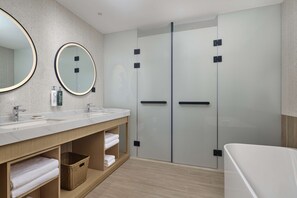 Un baño moderno con dos lavamanos, un espejo grande y una cabina de ducha de vidrio.
