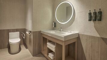 Een moderne badkamer met toilet, wastafel, spiegel en handdoekenkast.