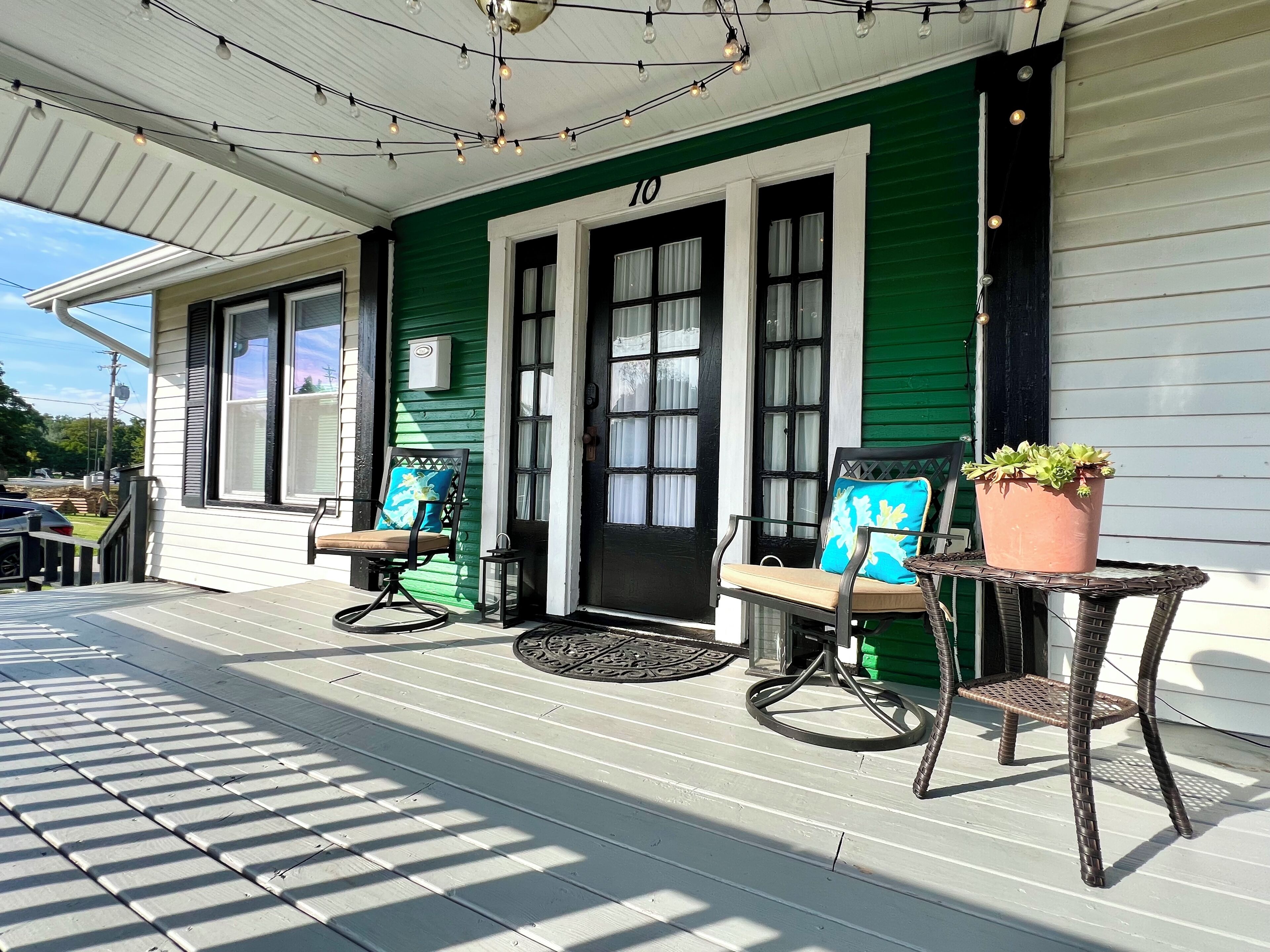 A porch with two chairs, a potted plant, and a number '10' on the door.