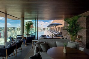 Un área lounge moderna con asientos y vista a la piscina.