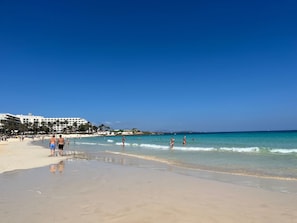 Une plage avec un hôtel en arrière-plan.