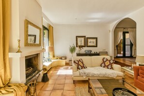 A living room with a fireplace, sofa, armchairs, and a dining area. - Villa 'Maria' with Private Pool, Wi-Fi and Air Conditioning (Navata)