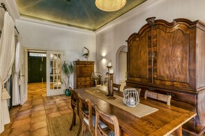 A dining area with a wooden table, chairs, a cabinet, and a door leading to another room. - Villa 'Maria' with Private Pool, Wi-Fi and Air Conditioning (Navata)