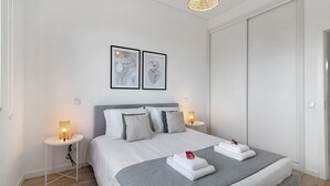A modern hotel room with a bed, bedside tables, and artwork on the wall. - "Formosa Home" Apartment with Lake View, Balcony & Wi-Fi (Faro)