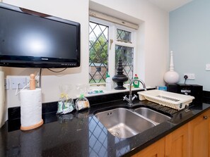 Enjoy cooking in this well-equipped kitchen with a flat-screen TV and stainless steel sink.