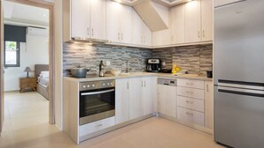 Une cuisine moderne avec des meubles de couleur bois clair, un four encastré, un réfrigérateur et un crédence carrelée.