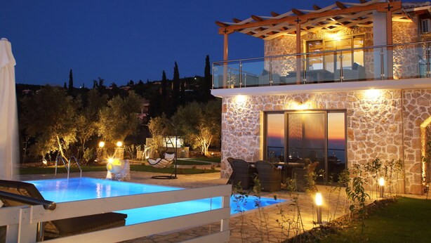 Un edificio de piedra con piscina, mobiliario exterior y vistas al paisaje.