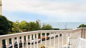 A balcony with a view of parked cars and a body of water. - The Lookout - Beautiful sea views (Filey)