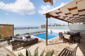A rooftop pool area with lounge chairs, a table, and a pergola. - Apartment 'Suite Iro' with Sea View, Wi-Fi and Air Conditioning (Lefkada)