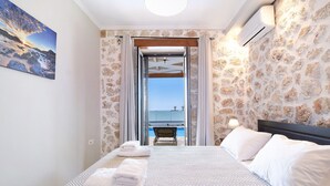 Ein Hotelzimmer mit Bett, Handtüchern, Meerblick und einem Balkon.