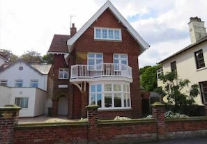 A two-story house with a balcony and a bay window.