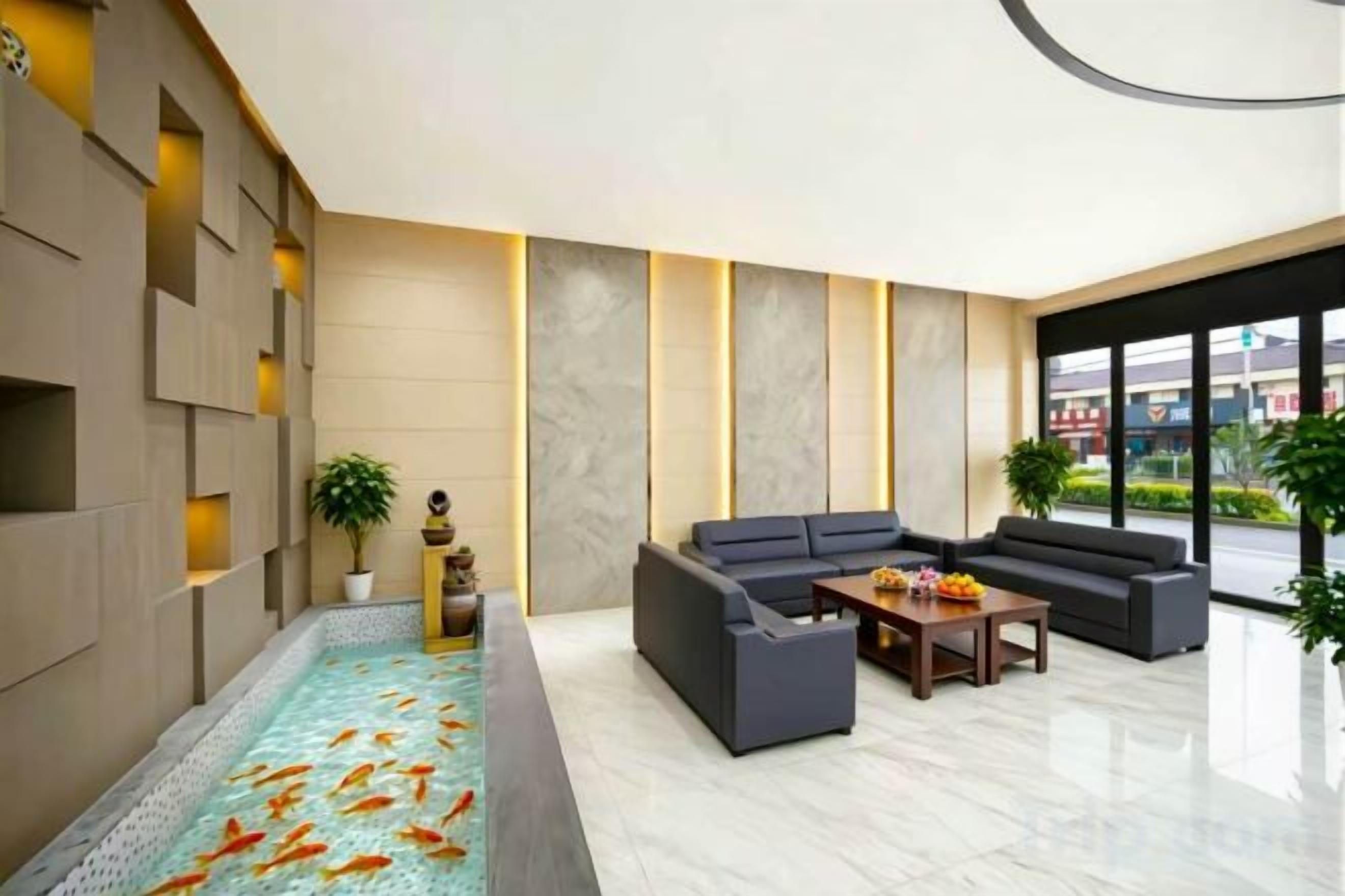 A modern lobby with a koi pond, seating area, and large windows.