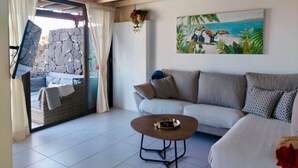 Ein Wohnzimmer mit einer Couch, einem Couchtisch, einem Gemälde und einer Steinwand.