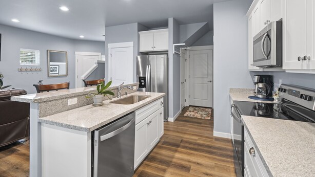 A modern kitchen with white cabinets, stainless steel appliances, and a granite countertop. - Welcome to The 255 — Your Home Away from Home (Parkland)