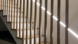 Un escalier moderne avec des rampes en bois et un éclairage encastré.