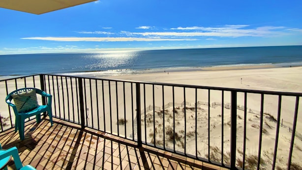 Un balcon avec vue sur une plage et l’océan.