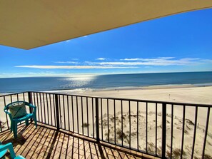 A balcony with a view of a beach and ocean.