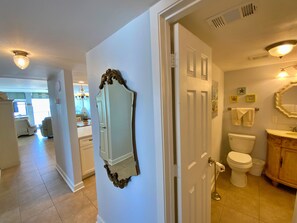 A bathroom with a toilet, sink, and mirror. - Gorgeous and Gulf Front! Pool! (Gulf Shores)