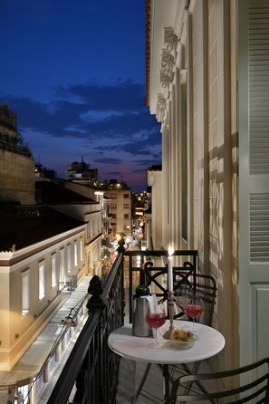 A balcony with a table set for two, featuring a candle, two wine glasses, and a bowl of food. - Athinaidos Platinum Loft by K&K (Αθήνα)