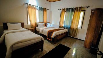 A hotel room with two beds, a wooden ceiling, and a large window with curtains.