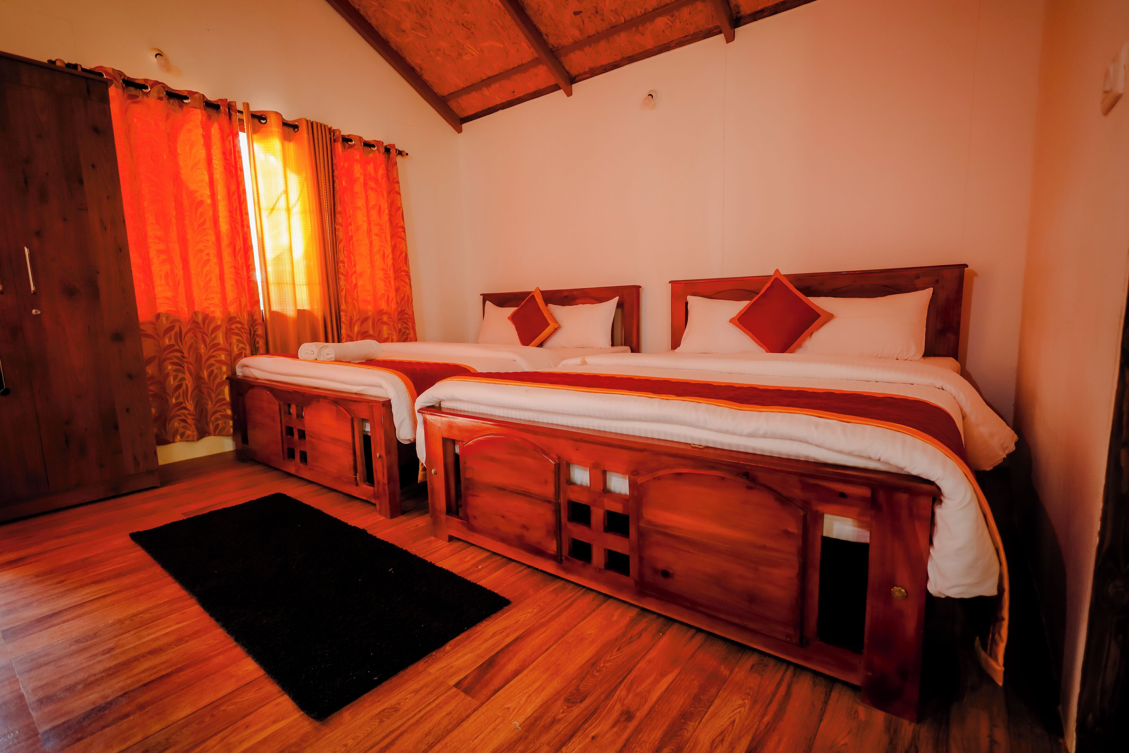 A room with two wooden beds, a black rug, and wooden walls.