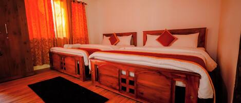 A room with two wooden beds, a black rug, and wooden walls.