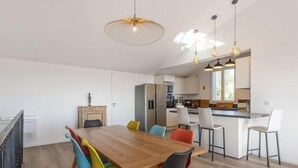 A modern kitchen with white cabinets, a central island, and pendant lighting. - Gazanias by Interhome (Bormes-les-Mimosas)