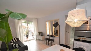 Eine moderne Wohnung mit Essbereich, Küche und einem Balkon mit Pflanzen.