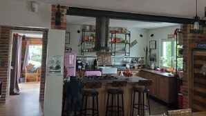 Eine Küche mit Kochinsel, Barhocker und einer Pendelleuchte.