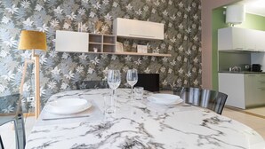 A dining area with a marble table, two wine glasses, and a lamp. - Italianway Collection - Cannobio 8 - Traviata (Milan)