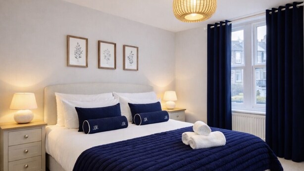 Una camera da letto ordinata con un letto, comodini e una finestra con tende.