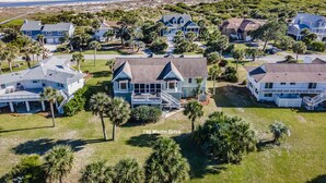 A coastal residential area with multiple houses, including a prominent house at 790 Marlin Drive with a large porch and a view of the ocean. - Sea Sounds -  steps to beach access, sleeps 17 and golf cart included (Fripp Island)