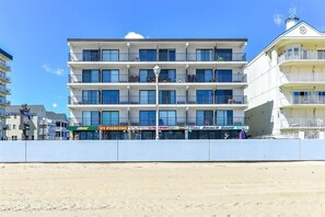 A multi-story hotel with balconies, a beach view, and various storefronts including Subway and NY Piercing. - Direct Oceanfront and Boardwalk Condo with Pool - Perfect Location! Decatur House 407 (Ocean City)