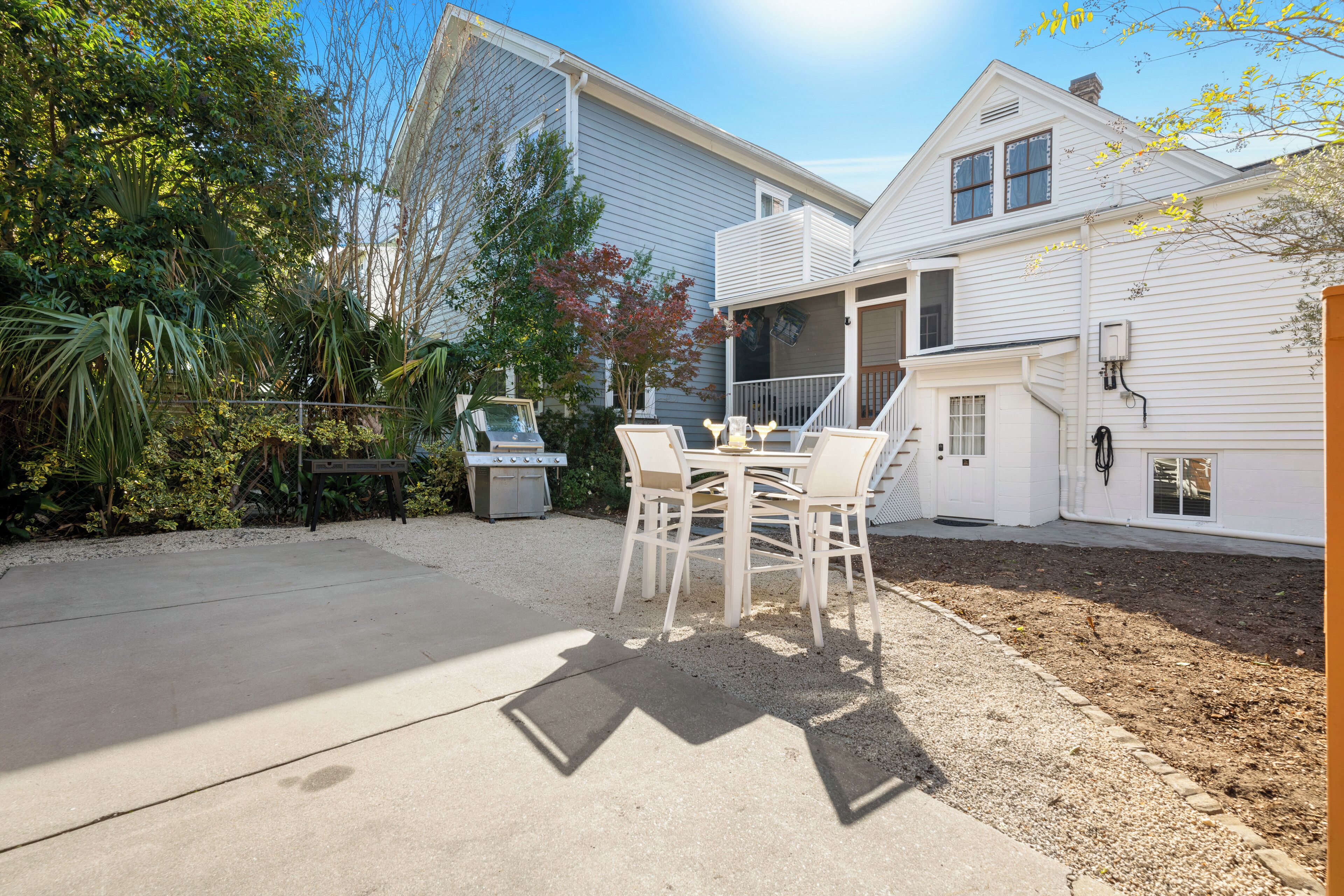 A house with a patio, a grill, and a covered outdoor seating area.