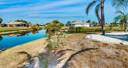 Palm-lined waterfront retreat with enclosed pool, inviting patio, & central AC