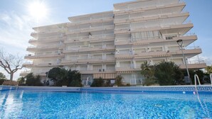 Ett hotell med flera våningar, där en swimmingpool syns tydligt på förgrunden.